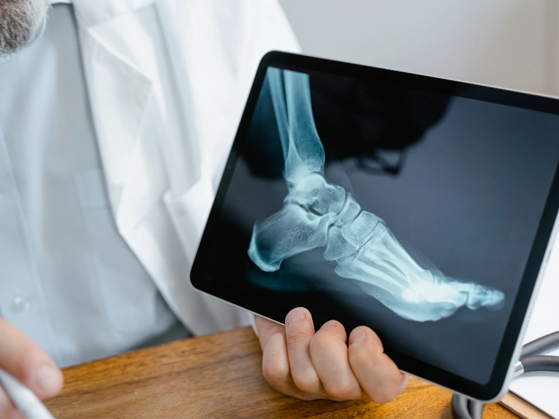 Ortopedico mostra una radiografia al paziente durante una visita specialistica.