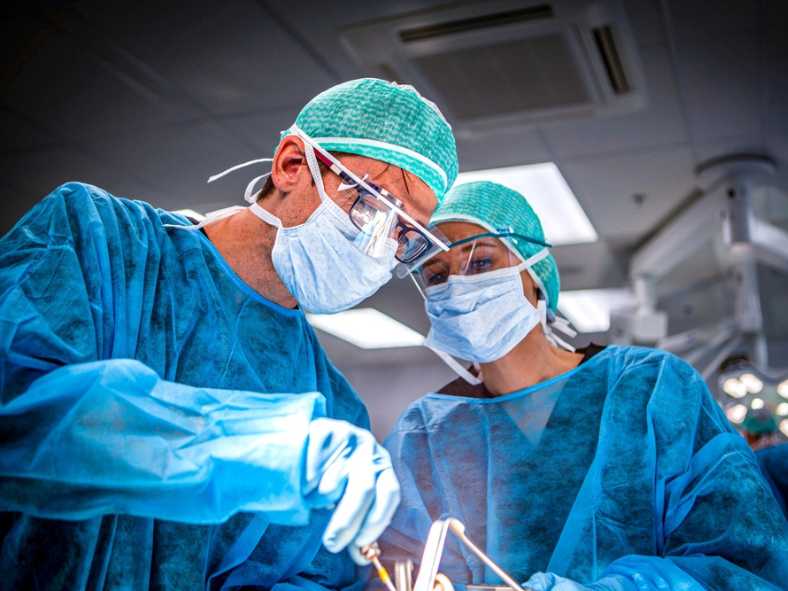 Medico ortopedico esperto spiega una procedura chirurgica a uno specializzando in ospedale